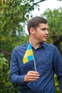 Ukrainian man. young man holding ukrainian flag. no war. support for ukraine. patriotic spirit 