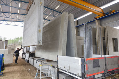 Worker sorting concrete segments in warehouse