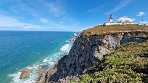 Lighthouse by sea against sky