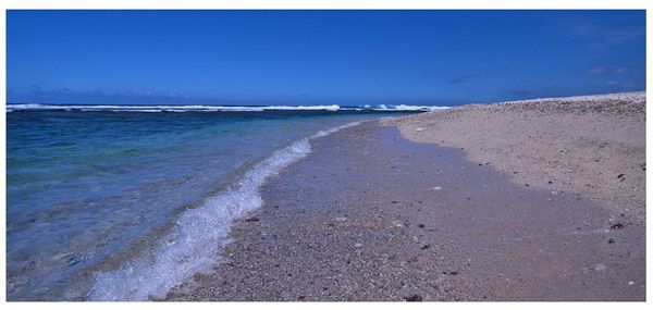 Scenic view of beach against clear blue sky