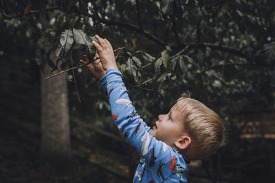 Boy holding plant outdoors