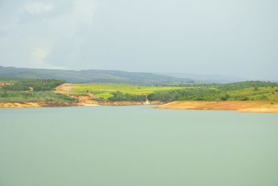 Scenic view of field by mountain against sky
