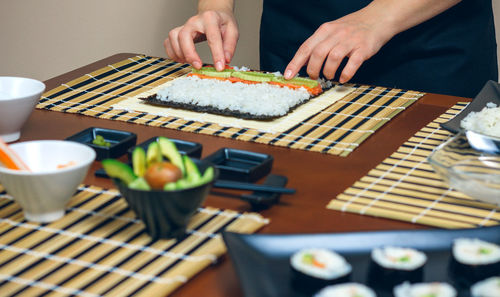 Midsection of person holding food on table