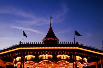 Low angle view of illuminated building against blue sky