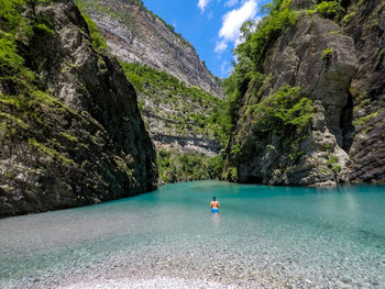 Scenic view of lake amidst rocks against sky