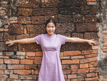 Woman wearing purple dress and old temple at sukhothai, thailand in march 13 2021