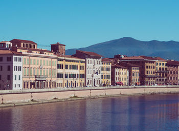 View of buildings in city against clear blue sky