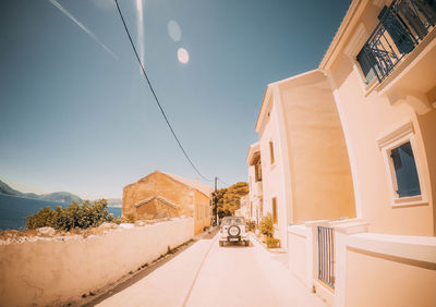 Road amidst buildings against sky