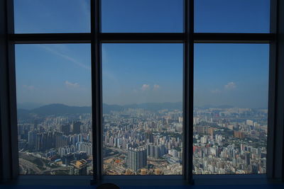 Cityscape against sky seen through glass window