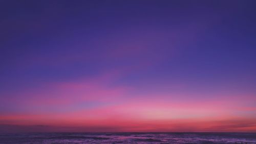 Scenic view of sea against dramatic sky during sunset