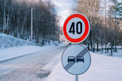 Close-up of road sign on snow covered field