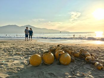 People on beach by sea against sky