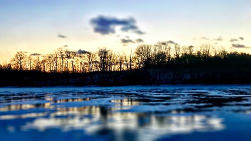 Scenic view of frozen river against sky during winter