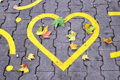 High angle view of yellow arrow symbol on street