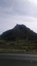 Road by mountain against sky