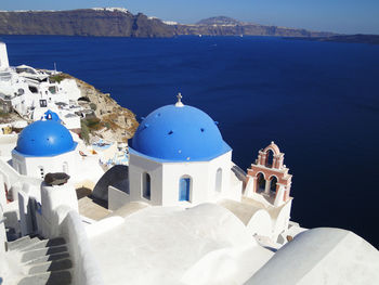 Traditional building by sea against blue sky