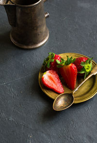 High angle view of sliced strawberries and spoon in plate