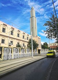 Road by building against sky in city