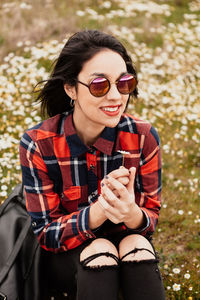 Young man wearing sunglasses sitting outdoors