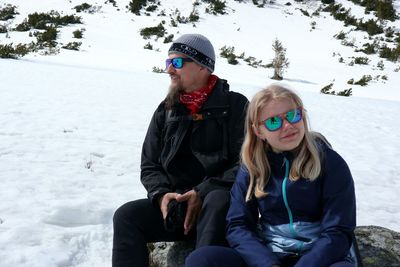 Full length of women sitting on snow during winter