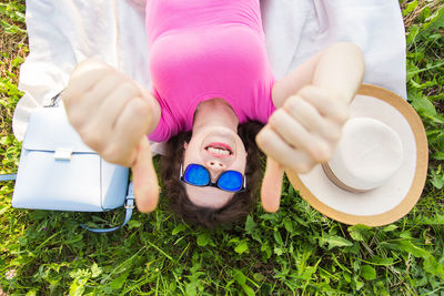 High angle portrait of smiling girl lying on grass