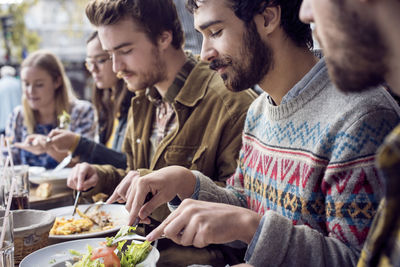 Male and female friends having lunch at outdoor restaurant