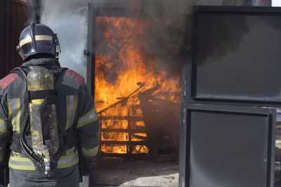 Rear view of firefighter working outdoors