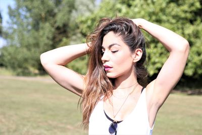 Young woman standing on field during sunny day