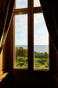 View from window over green garden and ocean at dunrobin castle in scotland 