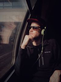 Portrait of young man sitting in train