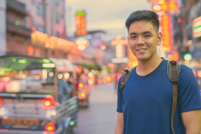 Portrait of smiling young man standing in city