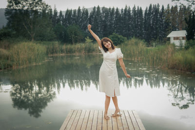 Rear view of woman standing against lake