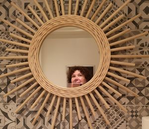 Woman taking selfie while reflecting on mirror