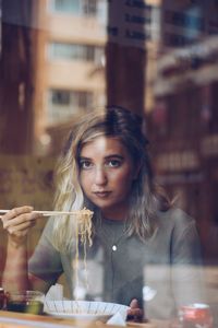 Portrait of young woman holding ice cream in restaurant