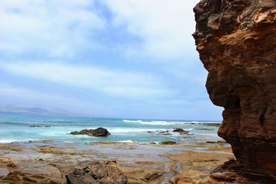 Rock formation in sea against sky