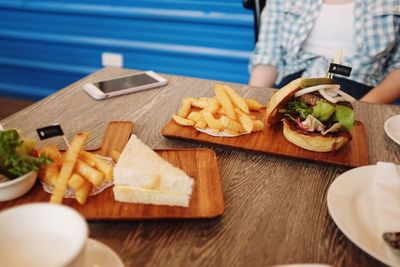High angle view of sandwich with french fries on wooden table