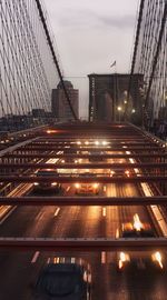 Illuminated suspension bridge against sky at night