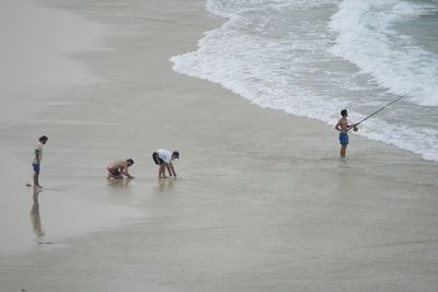 High angle view of people standing on beach