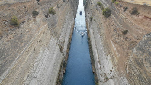 High angle view of boat moving on river amidst cliffs