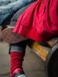 Low section of person holding red umbrella