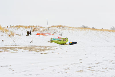 Panoramic view of fisher boats on snowy beach of baltic sea against clear sky