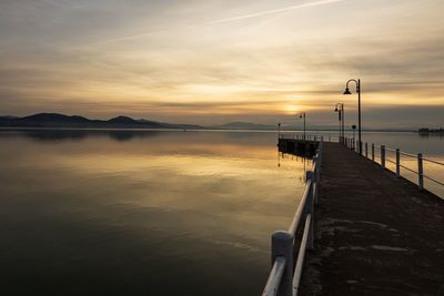 Pier over sea against sky during sunset