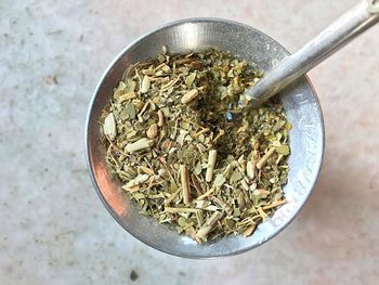 High angle view of herbs in mortar and pestle on table