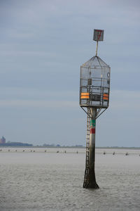 Lifeguard tower on beach against sky