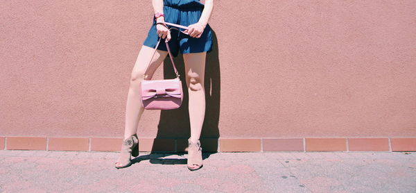 Low section of woman standing on wall