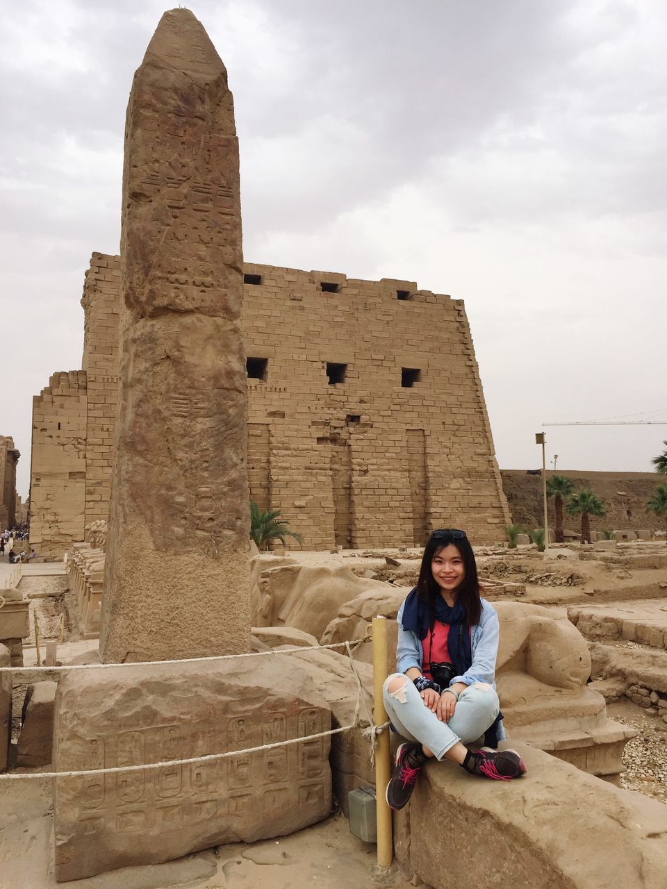 lifestyles, young adult, leisure activity, architecture, person, built structure, building exterior, casual clothing, full length, history, sky, young women, old ruin, looking at camera, sitting, smiling, standing
