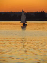 Boats in calm sea at sunset