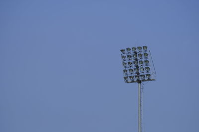 Low angle view of floodlight against clear blue sky