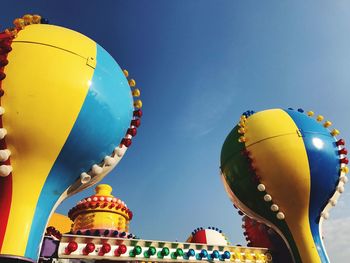 Low angle view of colorful amusement park against sky