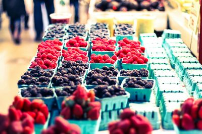 Cardboard boxes of blueberries and raspberries for sale